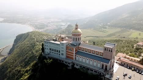 Drone-flight-over-the-sanctuary-of-Tindari,-Sicily,-Italy-with-the-mediterranean-Sea-in-the-background