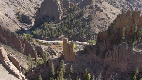 tilting drone shot of a standalone climbing rock near sunset in the rocky mountains