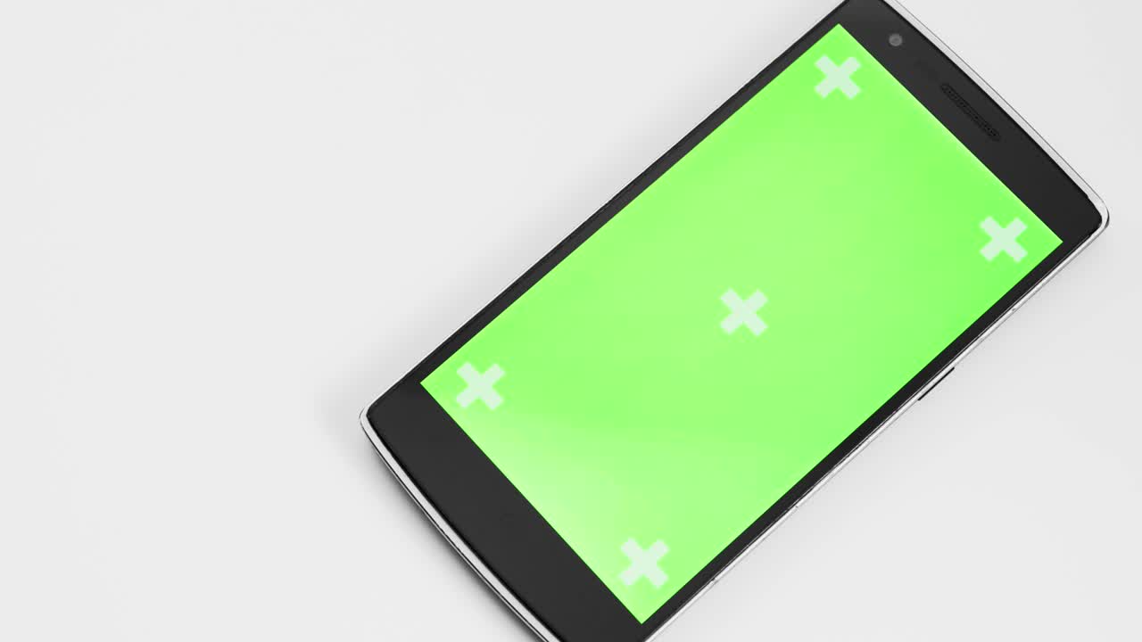 Smart Phone On White Table With Chroma Green Screen And Tracker Markers Panning Closeup