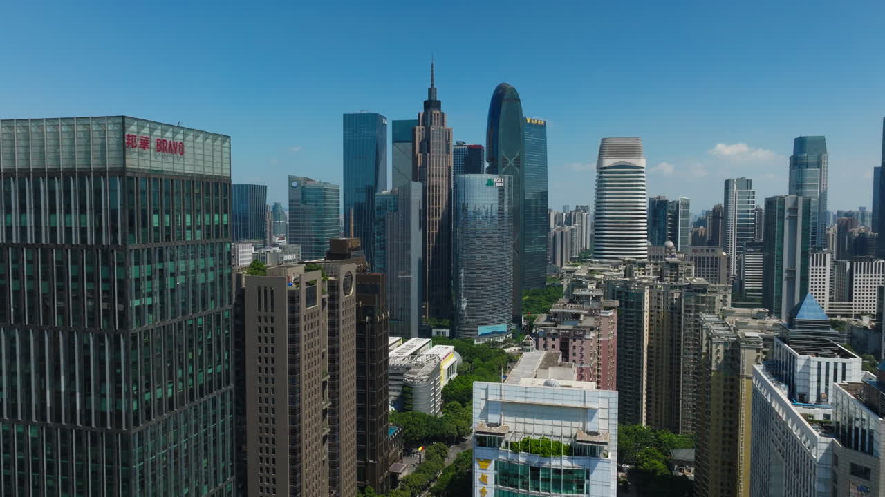 Guangzhou's downtown skyline on a sunny day with tall skyscrapers and blue sky, aerial view