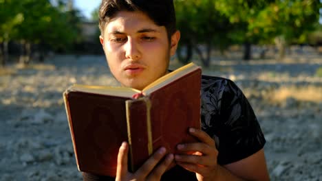 adolescente leyendo el corán en el jardín