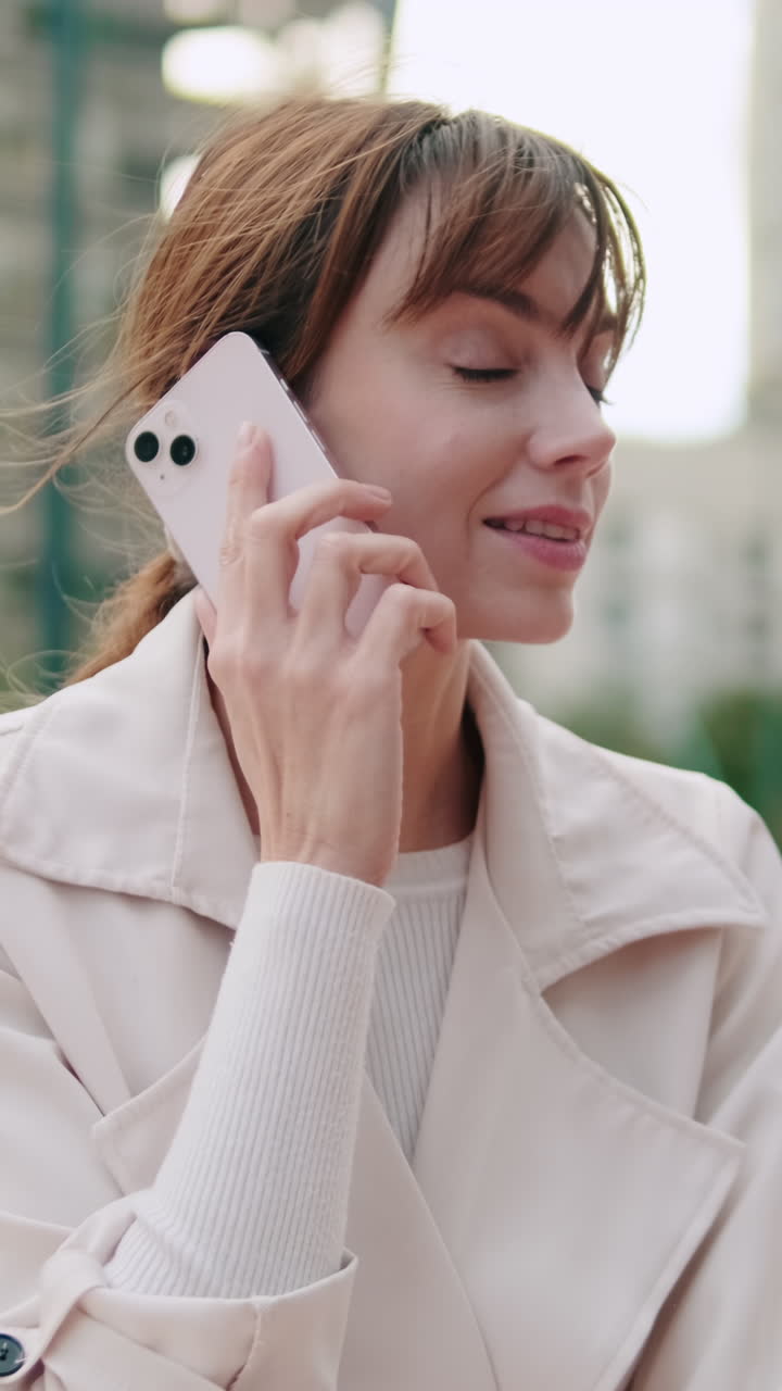 Donna felice che parla al telefono all'aperto in città