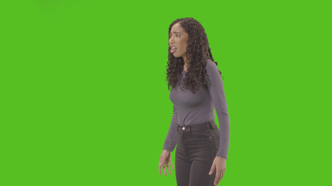 Three Quarter Length Shot Of Angry Looking Woman Shouting At Camera Against Green Screen