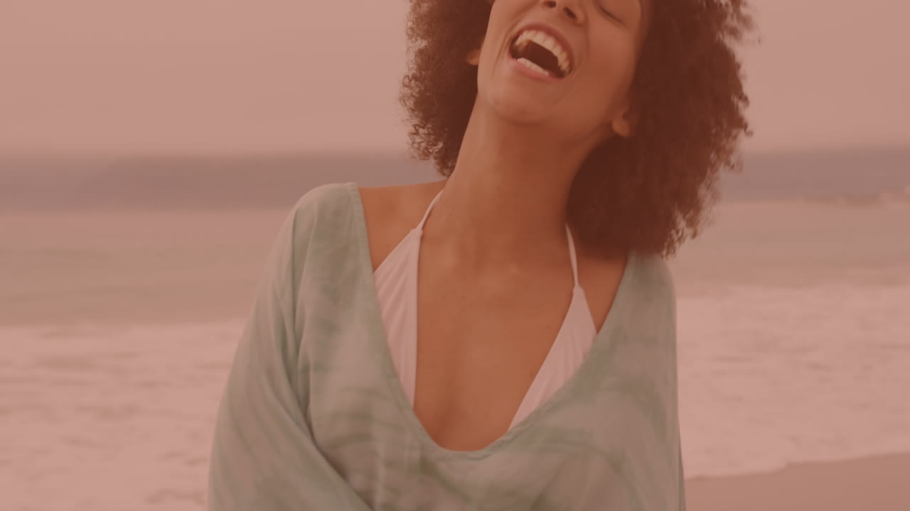 retrato de una mujer afroamericana sonriendo y disfrutando en la playa