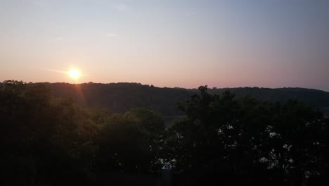 rising aerial shot of the sun rising over lake monroe in indiana