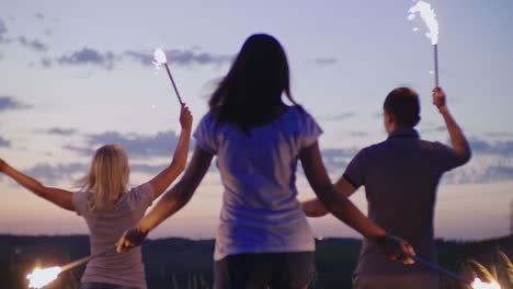 un grupo de amigos divirtiéndose con fuegos artificiales o luces de bengala