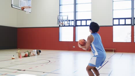 Afroamerikanischer-Männlicher-Basketballspieler-Schießt-Ball-Auf-Korb,-Training-Auf-Dem-Hallenplatz,-Zeitlupe