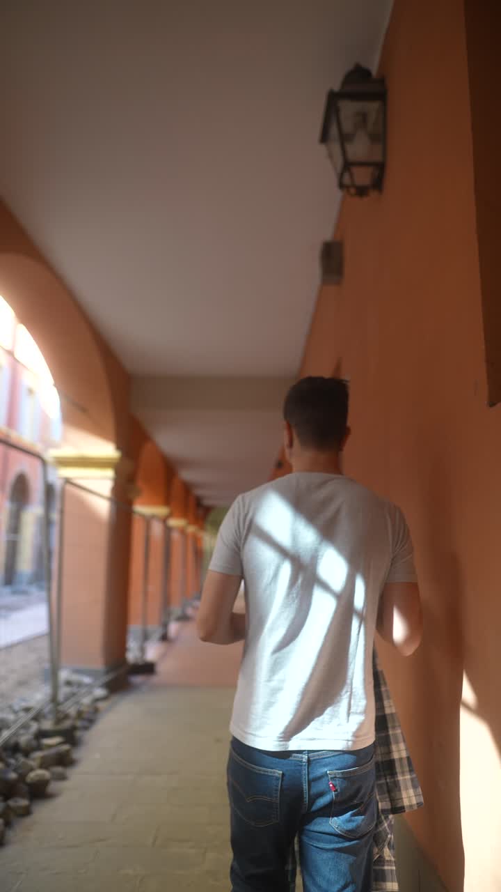 hombre caminando por un callejón arqueado