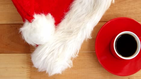 primer plano de una taza de café con un platillo y un sombrero de papá noel