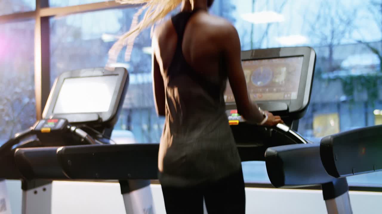 Rear view of fit woman exercising on treadmill