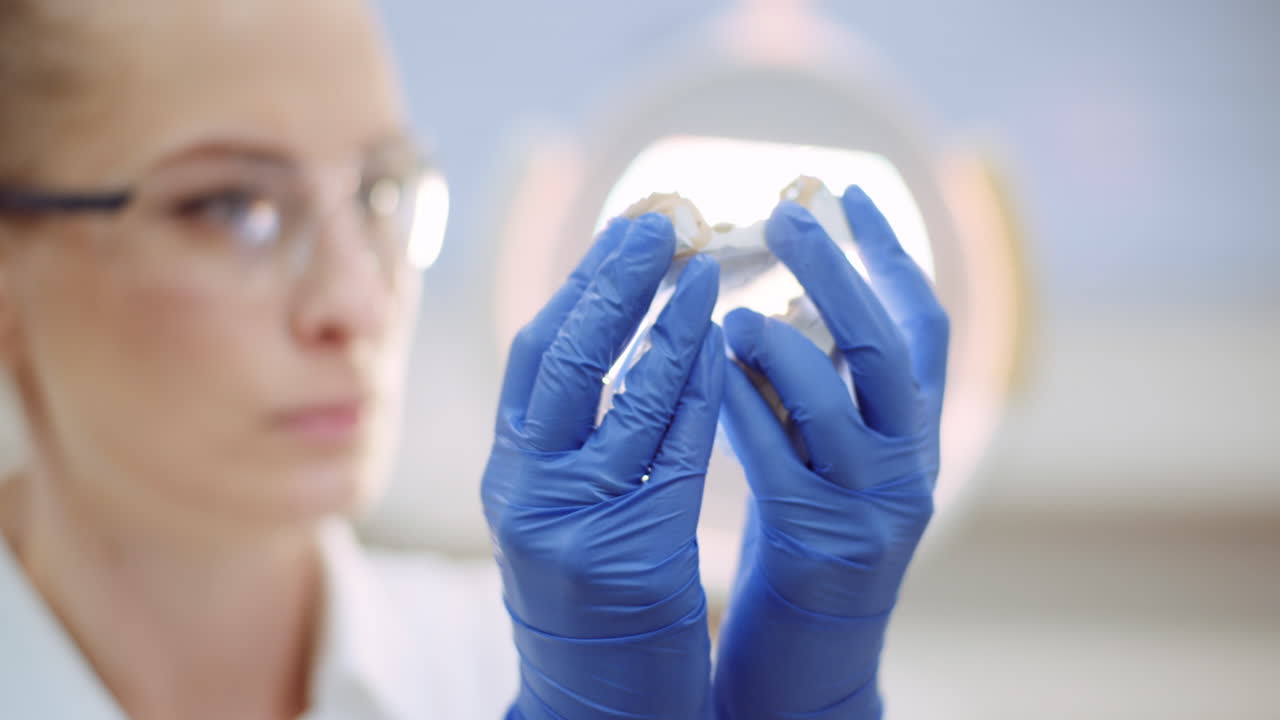 prótesis de dentista mirando dentadura postiza o yeso de mandíbula 2