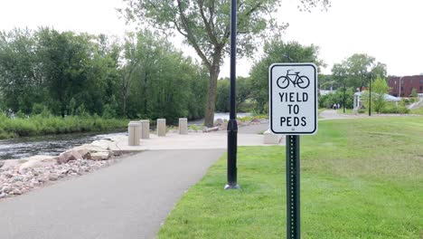 Yield-to-peds-sign-in-a-public-park-in-Chippewa-Falls,-Wisconsin