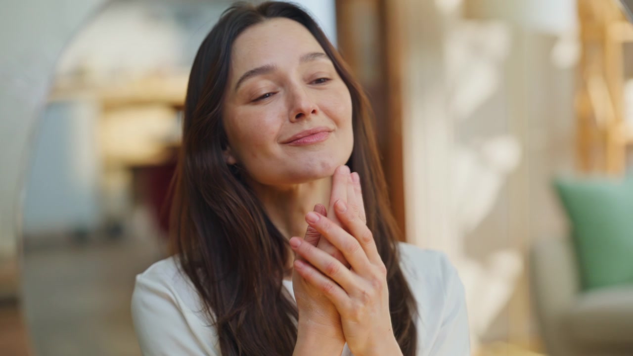 Primo piano delle mani di una donna che aprono un contenitore di crema per la cura della pelle durante il rituale di bellezza mattutino a casa.