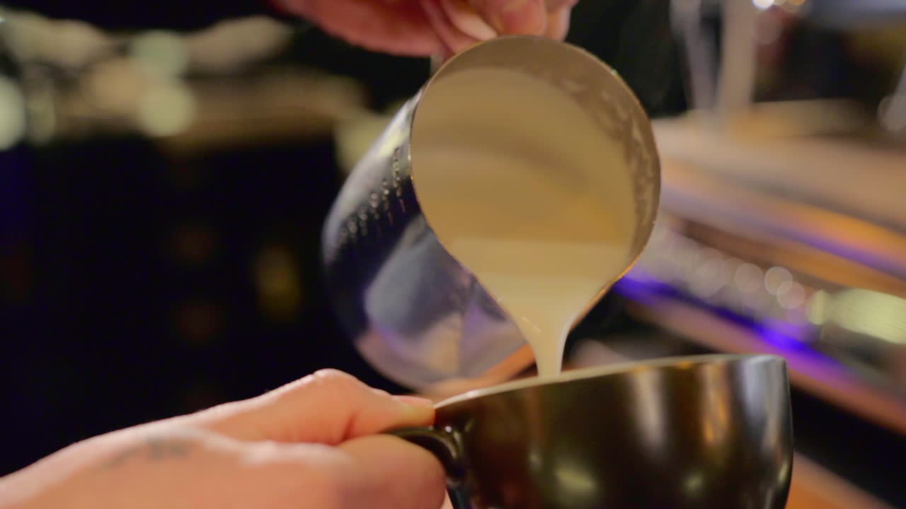 Making a foam heart on a coffee cup slow motion.
