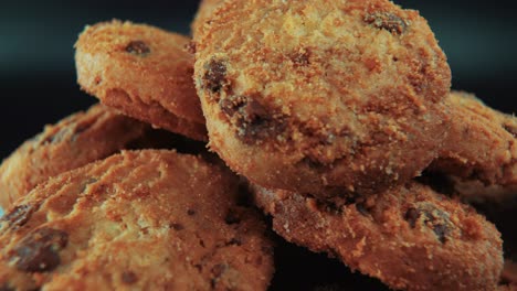 a macro close up cinematic shot of a pile full of crispy juicy chocolate chip cookies, on a rotating stand, professional studio lighting, slow motion, smooth movement, 4k video