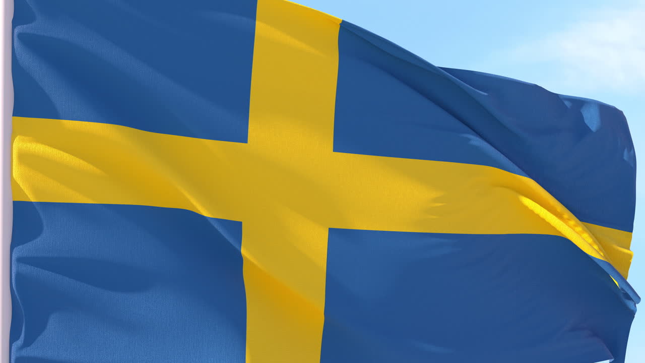 Svensk flag vajende i vinden mod blå himmel