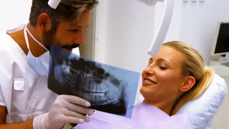 dentista discutiendo rayos x con una paciente femenina