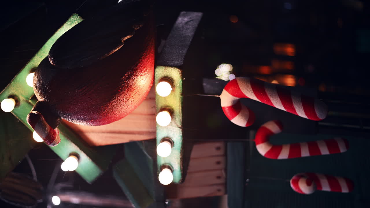 Bright lights and cheerful decorations fill the market as visitors enjoy the holiday spirit. Colorful candy canes dangle near glowing bulbs, adding to the festive charm