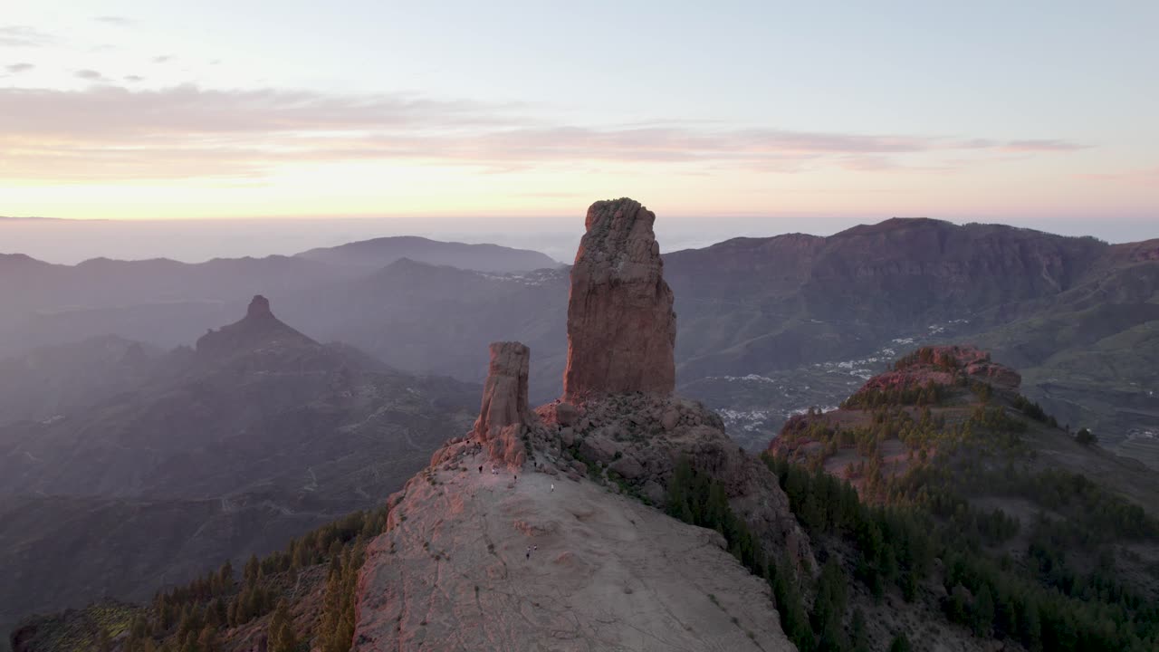 Birds eye view around Roque Nublo with an orange glow from the sunset on the island of Gran Canaria.