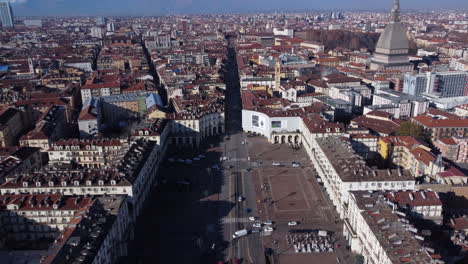 aerial flying forward over turin on sunny day, mole antonelliana on right side, italy