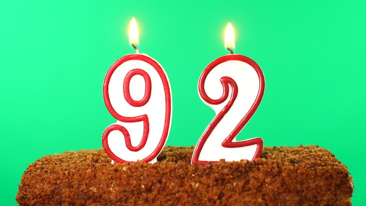 торт с номером 92 зажженной свечой. ключ хромы. зеленый экран. изолирован
