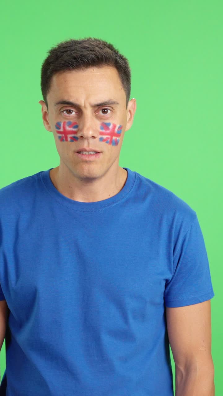 Man standing with british flag painted on face smiling