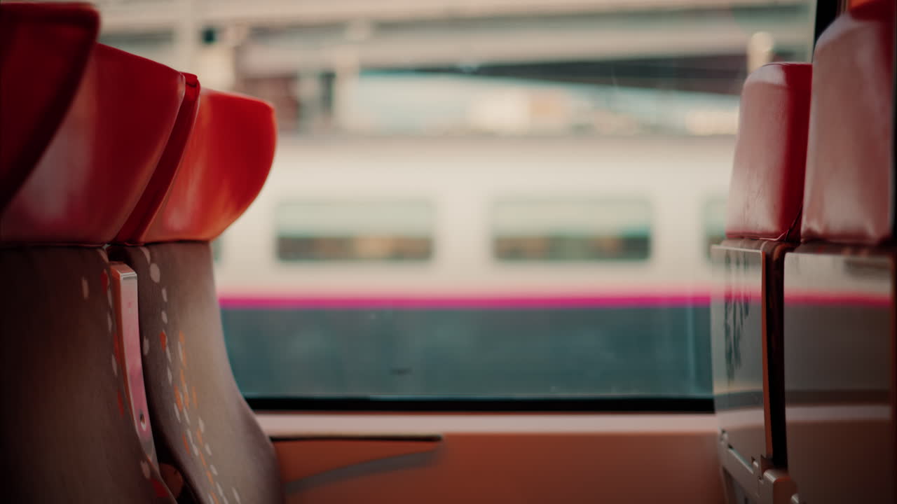 Close up of the seats near the window of a moving train with a blurry view