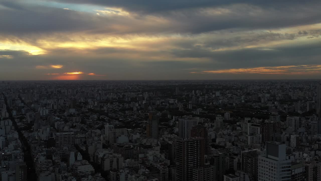 Drone flight over Buenos Aires during sunset, with the city's outline against the fading daylight
