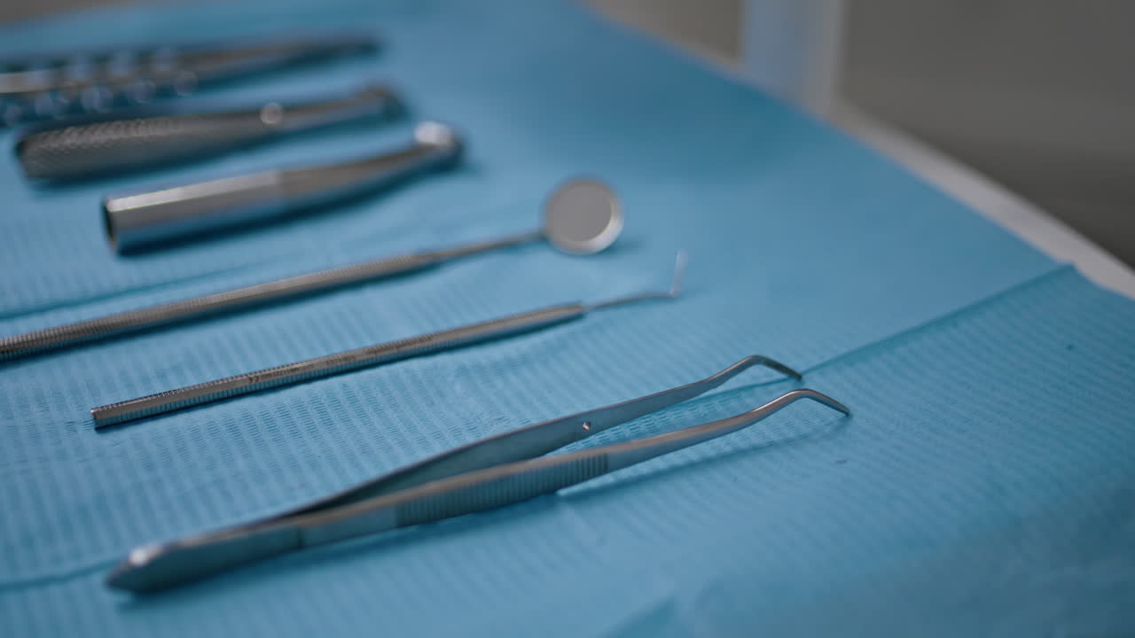 Closeup sterilized dental tools arranged on blue cloth modern clinic. Dentistry