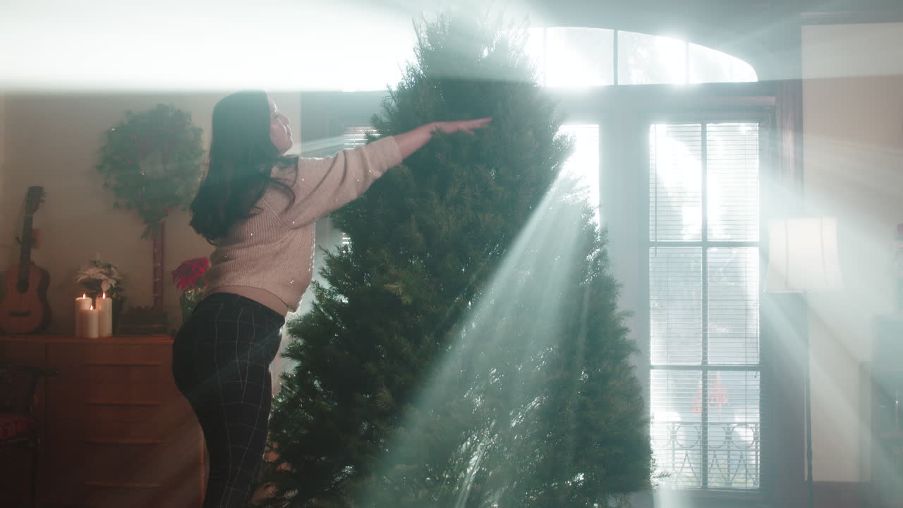 Woman Decorating Christmas Tree with Sun Rays