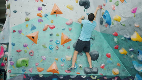 hombre bouldering en la pared de escalada