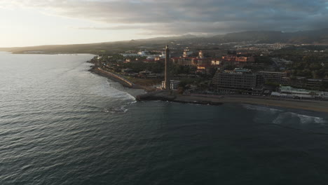 dunas de maspalomas, gran canaria: vista aérea viajando hacia el faro de maspalamas y volando sobre el océano y la costa