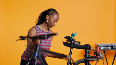 mechanic setting up bike repair stand, studio background