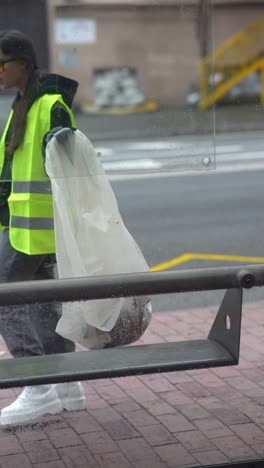 street cleaner at a bus stop on a rainy day