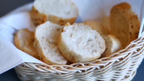 woman picking slices of bread from basket