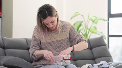 woman sorting pills and medicine into a storage container at home