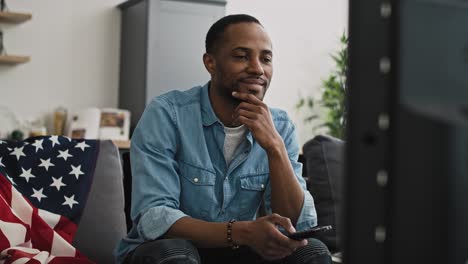 Handheld-video-of-satisfied-black-man-watching-TV