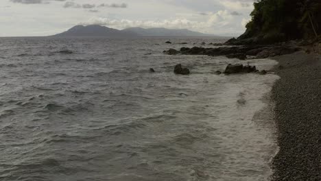 Las-Olas-Del-Océano-Chocan-Y-Esparcen-Espuma-De-Cal-En-La-Playa-De-Guijarros,-Perfecta-Serenidad