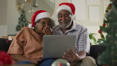 Animation-of-happy-african-american-senior-couple-having-video-call-at-christmas-time