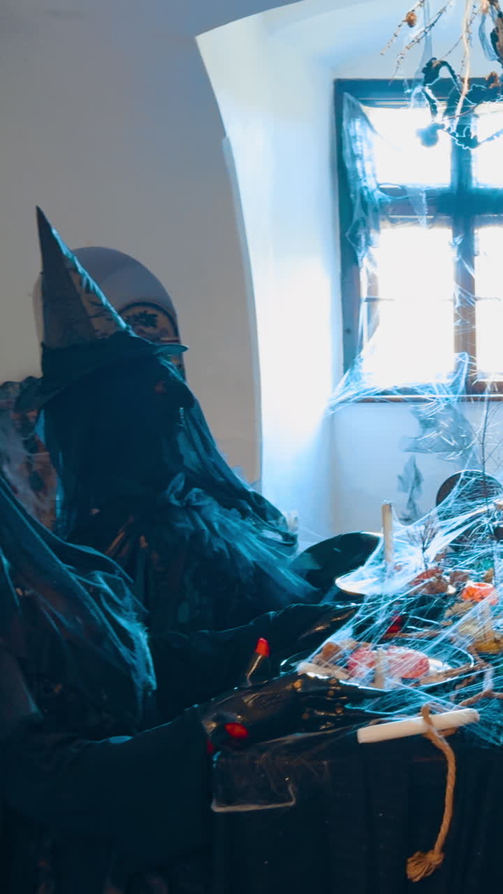 Entering the little room with four figures of four witches having festive dinner. Halloween decoration of the old castle. Vertical video