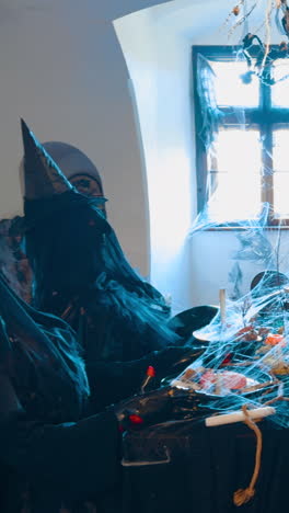 entering the little room with four figures of four witches having festive dinner. halloween decoration of the old castle. vertical video