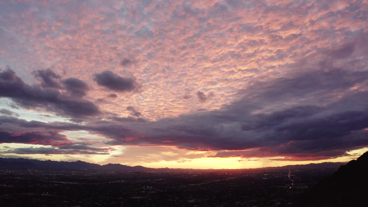 Tilting shot from pink sunlit sky to dark neighborhoods in Arizona