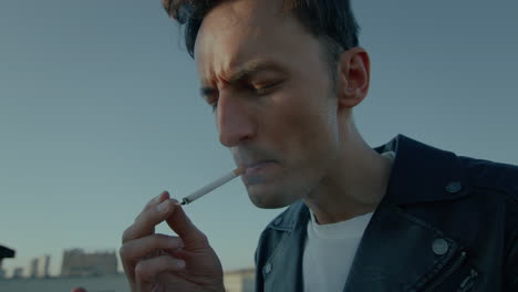 young man lighting cigarette, smoking, black lather jacket, careless