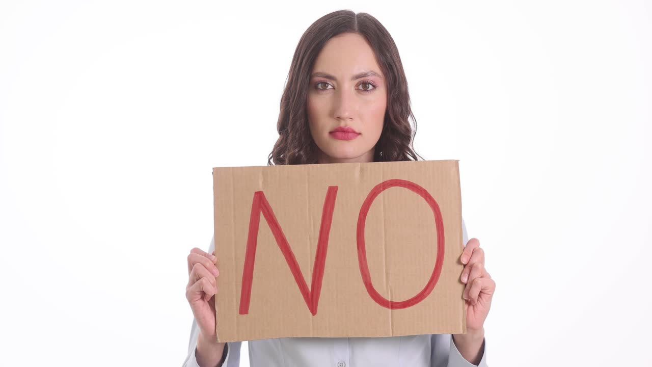 Woman holding 'NO' sign on cardboard
