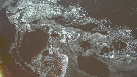 aerial view of changing patterns of foam on the surface of the water