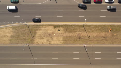 una vista de arriba hacia abajo directamente sobre la mediana de una autopista en un día soleado