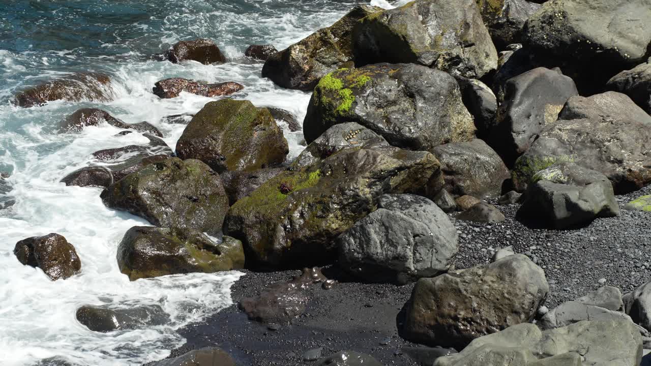 Onde dell'Oceano Atlantico che scorrono sulle rocce sull'isola di Tenerife, ripresa a mano libera.