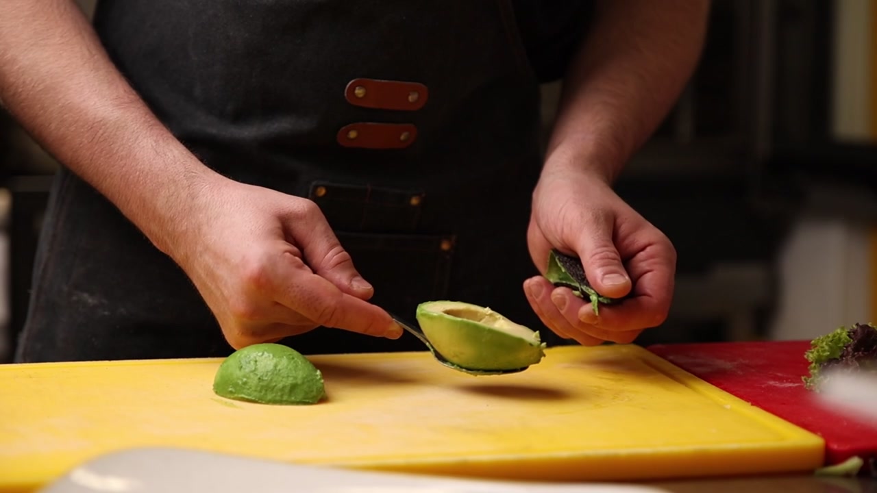 Chef che estrae la polpa fresca di avocado dalla sua buccia
