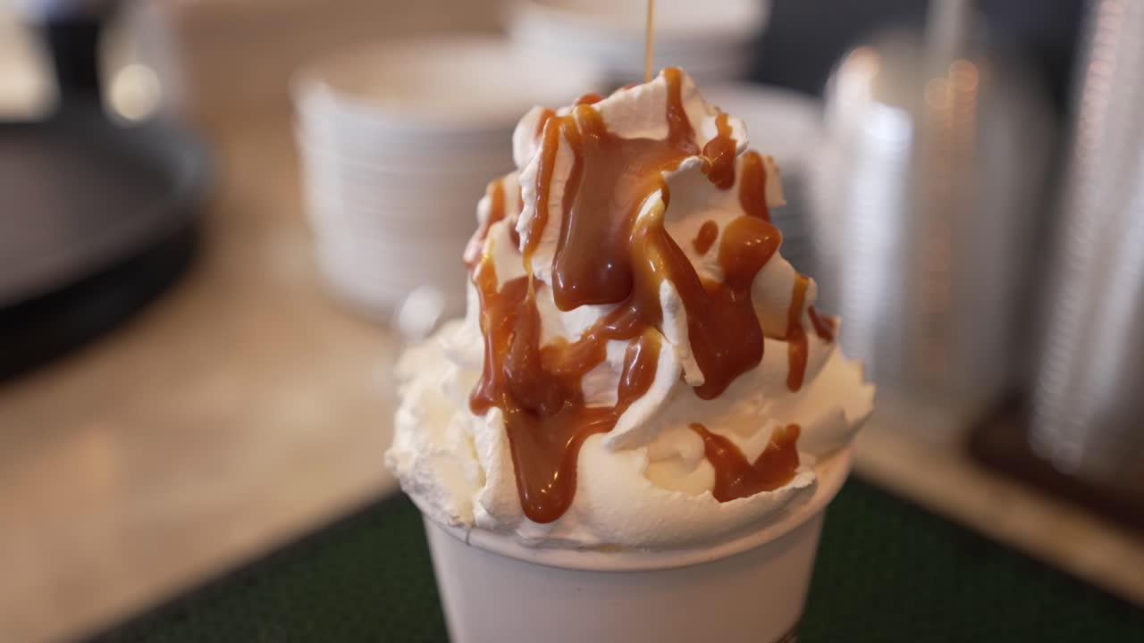 라떼에 캐러멜을 붓고, 카페에서 달콤한 음료 준비