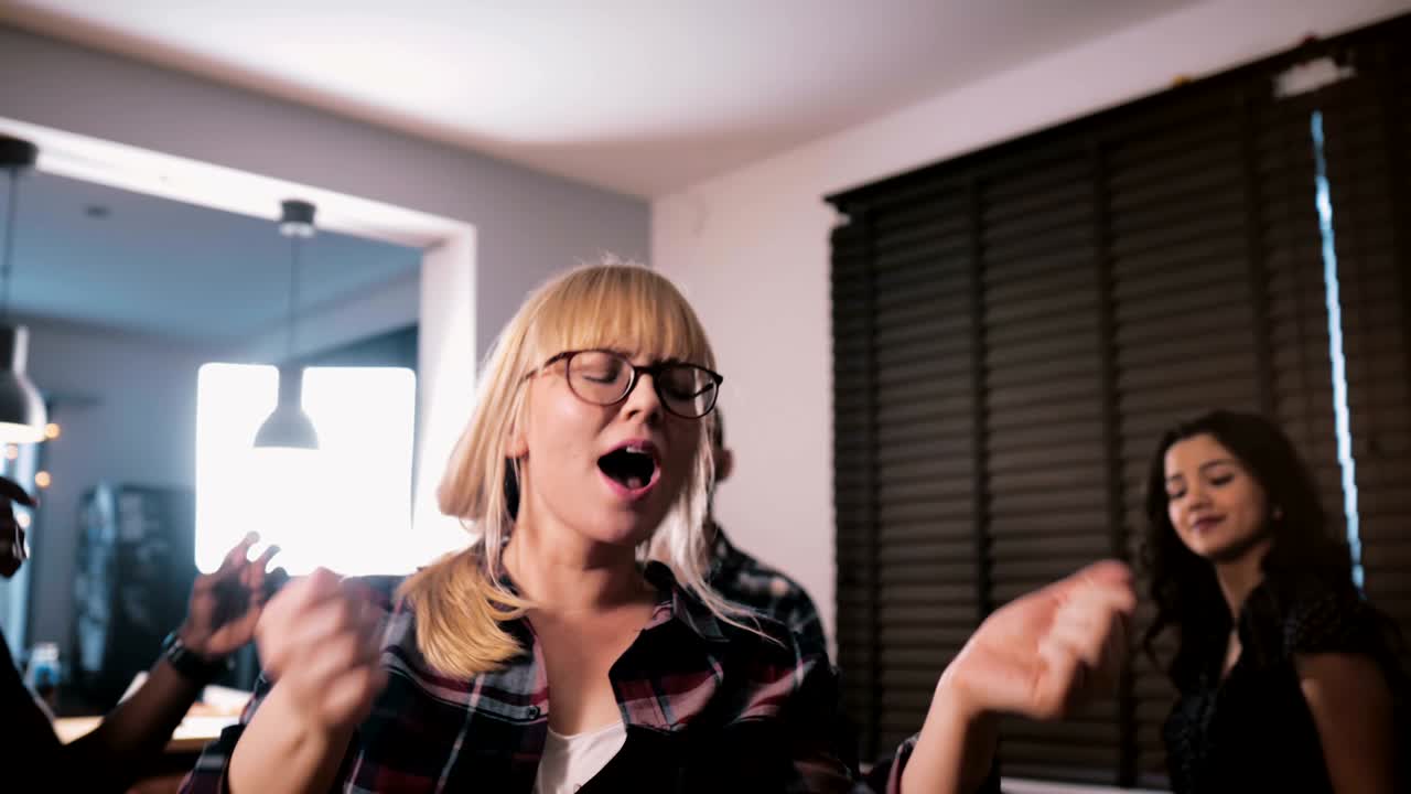 아름다운 유럽 소녀가 집에서 춤을 추고 웃으며 혼혈 친구들과 함께 생일 파티를 열고 슬로우 모션 클로즈업